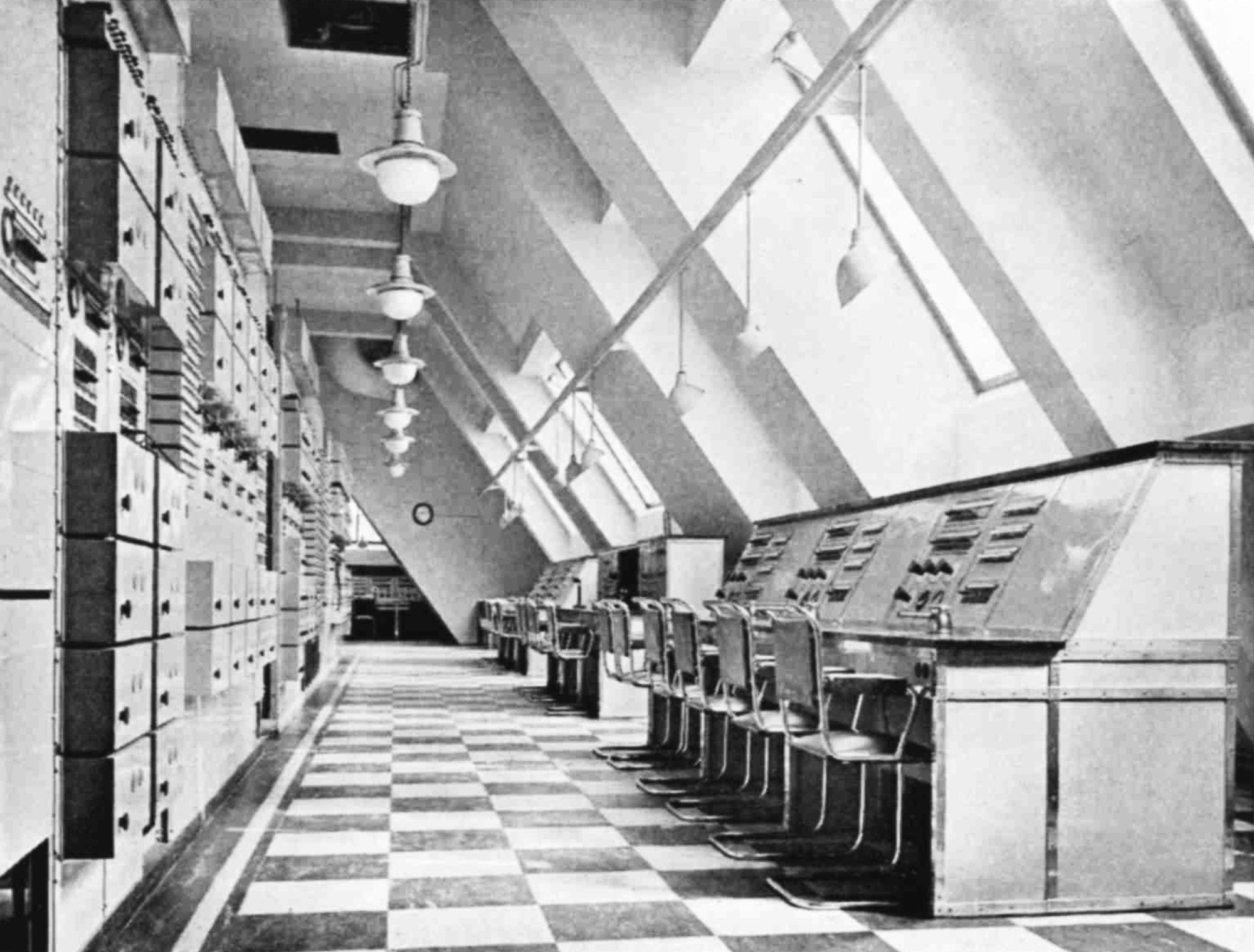 Looking down a long corridor with desks on the right and machinery lining the left