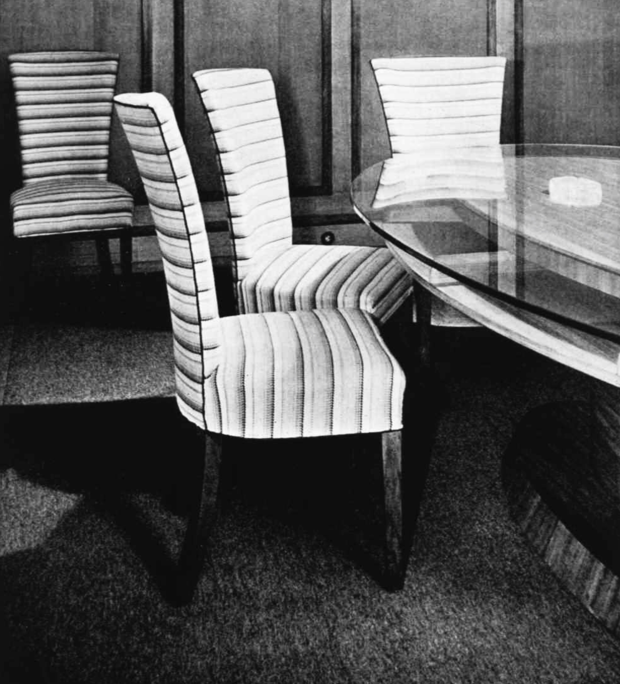 Armless upholstered chairs around a glass-topped table